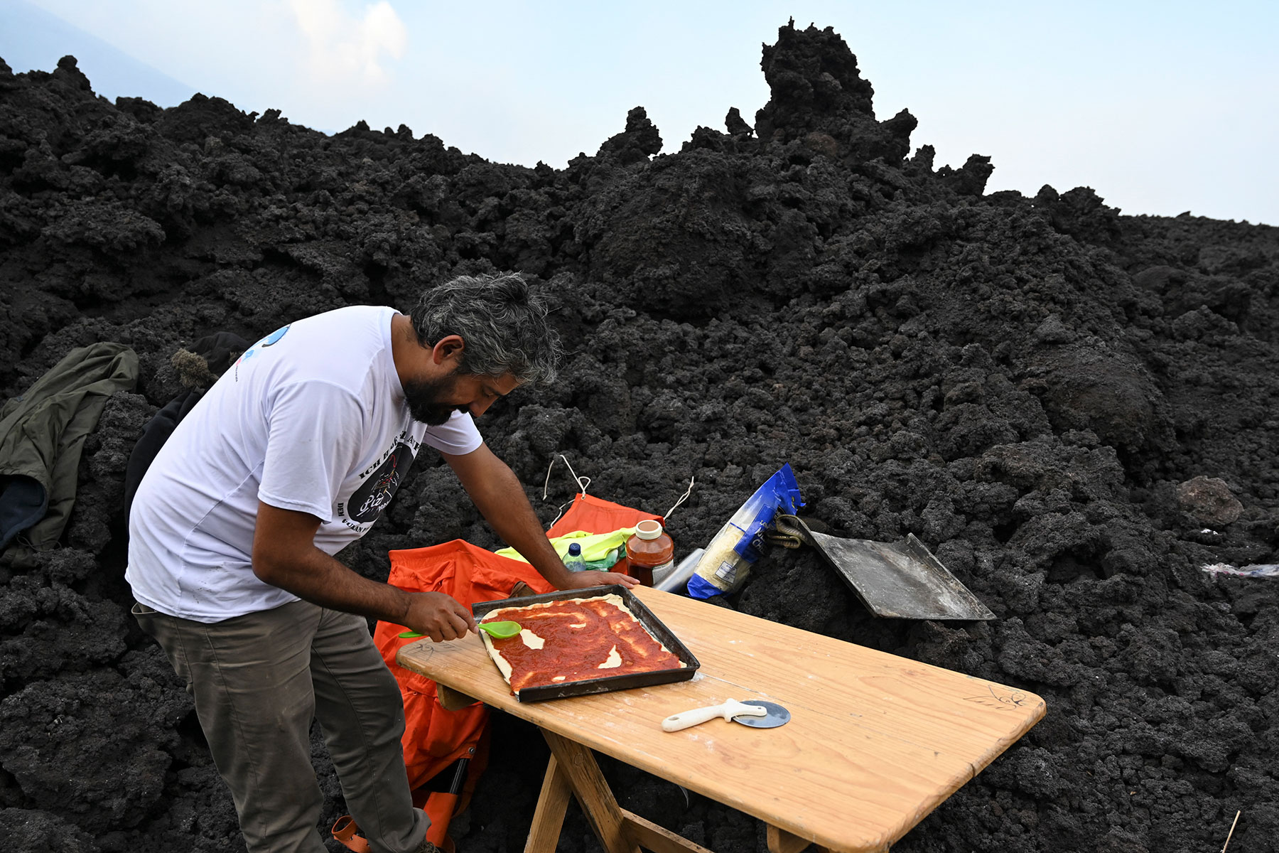 Chef serve pizza cozida com lava real no topo de um vulcão ativo na Guatemala